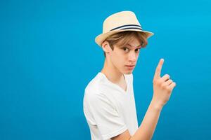 Attractive teen boy with seriosly facial expression pointing up with finger, presenting copy space. photo