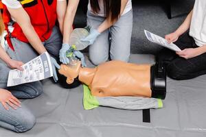 Woman holding breathing bag Ambu bag.Demonstrating CPR Cardiopulmonary resuscitation training medical procedure on CPR doll in the class.Paramedic demonstrate first aid practice for save life photo
