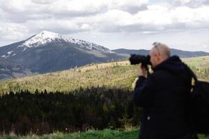 Photographer capturing mountain view in spring photo