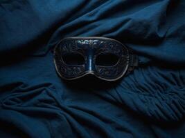 Sleep eye mask and blanket on dark blue background, top view Insomnia, fall asleep concept Flat lay, top view. photo