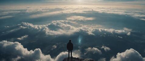 A man is standing in the clouds, looking down at the earth below. photo