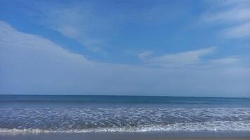 a beach with a blue sky and white clouds photo
