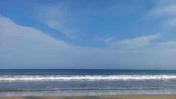 a beach with a blue sky and white clouds photo