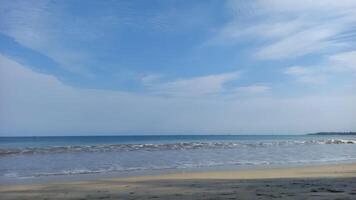 a beach with a blue sky and white clouds photo