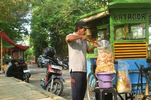 A man who sells snacks on a typical Indonesian street namely Batagor photo