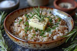 A bowl of kasha, a traditional buckwheat porridge, garnished with a pat of butter and a sprinkle of salt. photo