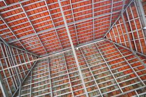 Roof construction photographed from below, composed of tiles and hollow iron photo