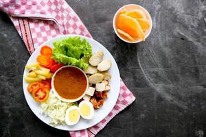 Gado-gado is a traditional Indonesian salad consisting of vegetables, potatoes, tempeh, tofu, carrots, tomatoes, lettuce, eggs and peanut sauce. Salad photo