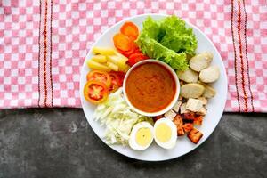 Gado-gado is a traditional Indonesian salad consisting of vegetables, potatoes, tempeh, tofu, carrots, tomatoes, lettuce, eggs and peanut sauce. Salad photo