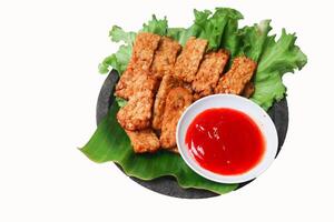 Tempeh Tempe Goreng or Fried tempeh is Indonesia traditional food made from fermented soybean seeds with sambal chilli sauce isolated white background photo
