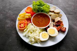 Gado-gado is a traditional Indonesian salad consisting of vegetables, potatoes, tempeh, tofu, carrots, tomatoes, lettuce, eggs and peanut sauce. Salad photo