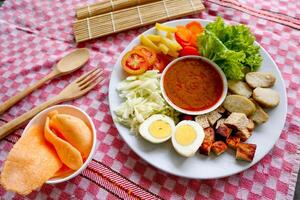 Gado-gado is a traditional Indonesian salad consisting of vegetables, potatoes, tempeh, tofu, carrots, tomatoes, lettuce, eggs and peanut sauce. Salad photo