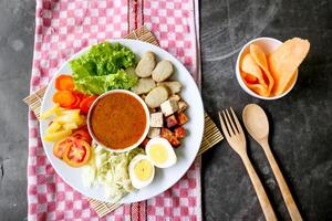 Gado-gado is a traditional Indonesian salad consisting of vegetables, potatoes, tempeh, tofu, carrots, tomatoes, lettuce, eggs and peanut sauce. Salad photo
