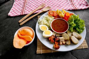 Gado-gado is a traditional Indonesian salad consisting of vegetables, potatoes, tempeh, tofu, carrots, tomatoes, lettuce, eggs and peanut sauce. Salad photo