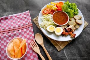Gado-gado is a traditional Indonesian salad consisting of vegetables, potatoes, tempeh, tofu, carrots, tomatoes, lettuce, eggs and peanut sauce. Salad photo