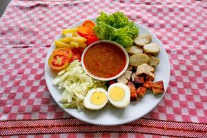 Gado-gado is a traditional Indonesian salad consisting of vegetables, potatoes, tempeh, tofu, carrots, tomatoes, lettuce, eggs and peanut sauce. Salad photo