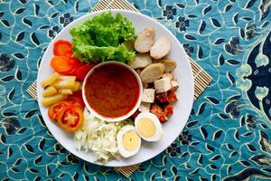 Gado-gado is a traditional Indonesian salad consisting of vegetables, potatoes, tempeh, tofu, carrots, tomatoes, lettuce, eggs and peanut sauce. Salad photo