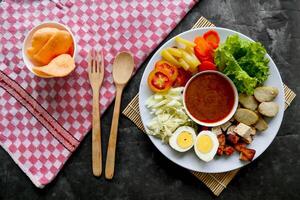 Gado-gado is a traditional Indonesian salad consisting of vegetables, potatoes, tempeh, tofu, carrots, tomatoes, lettuce, eggs and peanut sauce. Salad photo
