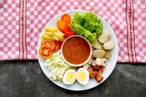 Gado-gado is a traditional Indonesian salad consisting of vegetables, potatoes, tempeh, tofu, carrots, tomatoes, lettuce, eggs and peanut sauce. Salad photo