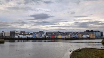 Cloudy Evening cityscape scenery, colourful houses at Long walk, Claddagh by Corrib river at Galway city, Ireland photo