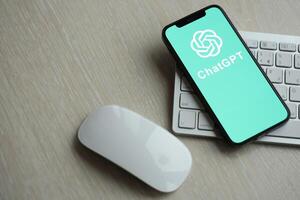 KYIV, UKRAINE - MARCH 17, 2024 ChatGPT logo on iPhone display screen with apple keyboard and mouse on table photo