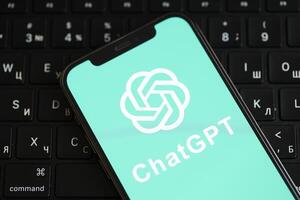 KYIV, UKRAINE - MARCH 17, 2024 ChatGPT logo on iPhone display screen and MacBook keyboard photo