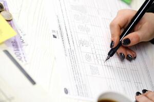 KYIV, UKRAINE - OCTOBER 31, 2023 Accountant fill french tax form 2041E Withholding tax declaration in end of tax period. Taxation and paperwork routine photo