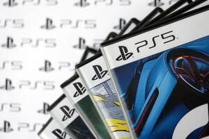 KYIV, UKRAINE - JUNE 26, 2024 Stack of games for Sony Playstation 5 and 4 console. Many disc boxes of popular games photo