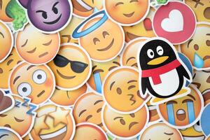 KYIV, UKRAINE - APRIL 20, 2024 Tencent QQ Weibo logo and large set of stickers with Emoji yellow faces. Emoji is a pictogram or smiley embedded in text and used in electronic messages photo