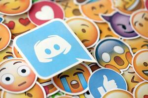 KYIV, UKRAINE - APRIL 20, 2024 Discord logo and large set of stickers with Emoji yellow faces. Emoji is a pictogram or smiley embedded in text and used in electronic messages photo