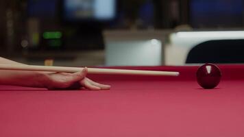 An example of the proper positioning of the hand underneath the cue when striking the ball in billiards. Close up. Slow motion video