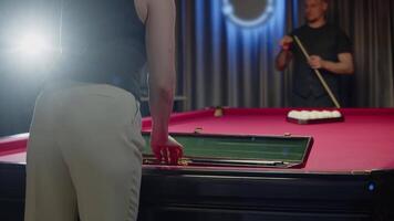 Girl opens the case and removes a cue. She is getting ready for a game of Russian billiards. Mid shot. Slow motion video