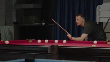 Tattooed professional billiards player is enthusiastically engaging in the game. video