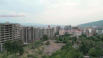 Aerial rising view construction site with crane cary block material and workers working. Real estate site in Saburtalo, Tbilisi, Georgia video
