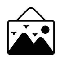 A framed landscape image with mountains, birds, and the sun hanging on a wall vector