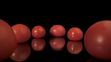 Close-up of red fresh ripe tomatoes on a glass surface. Juicy tomatoes are reflected in the mirror surface. video