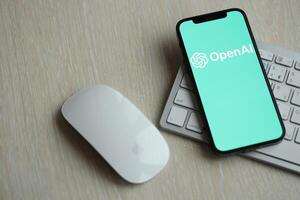 KYIV, UKRAINE - MARCH 17, 2024 OpenAI logo on iPhone display screen with apple keyboard and mouse on table photo