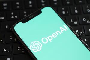 KYIV, UKRAINE - MARCH 17, 2024 OpenAI logo on iPhone display screen and MacBook keyboard photo