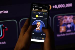 KYIV, UKRAINE - APRIL 20, 2024 Hamster Kombat telegram bot on smartphone screen. Hamster Kombat is a viral Telegram-based crypto game for earn HMSTR tokens by managing virtual crypto exchange photo