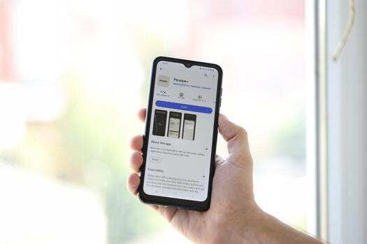 KYIV, UKRAINE - JUNE 20, 2024 Hand holds smartphone with Rezerv plus - ukrainian application for smartphone with actual personal information about conscript status photo