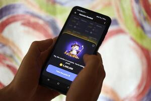 KYIV, UKRAINE - JUNE 26, 2024 Hamster Kombat telegram mini-game in tap 2 earn genre. Tap game on smartphone in hand photo