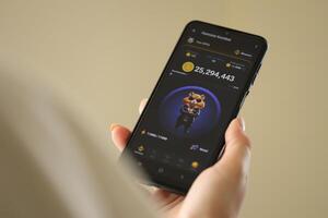 KYIV, UKRAINE - JUNE 20, 2024 Hamster Kombat tap 2 earn mini game in telegram messenger on smartphone display photo