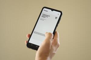 KYIV, UKRAINE - JUNE 20, 2024 Hand holds smartphone with Rezerv plus - ukrainian application for smartphone with actual personal information about conscript status photo