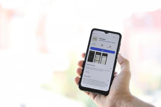 KYIV, UKRAINE - JUNE 20, 2024 Hand holds smartphone with Rezerv plus - ukrainian application for smartphone with actual personal information about conscript status photo