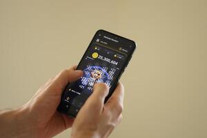 KYIV, UKRAINE - JUNE 20, 2024 Hamster Kombat tap 2 earn mini game in telegram messenger on smartphone display photo
