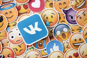KYIV, UKRAINE - APRIL 20, 2024 VK logo and large set of stickers with Emoji yellow faces. Emoji is a pictogram or smiley embedded in text and used in electronic messages photo