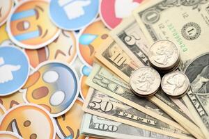 KYIV, UKRAINE - APRIL 20, 2024 USD dollars money and large set of stickers with Emoji yellow faces. The concept of smm, smo paid service for boost in social media photo
