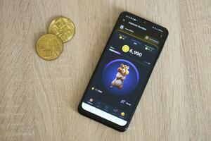 KYIV, UKRAINE - APRIL 20, 2024 Hamster Kombat telegram bot on smartphone screen. Hamster Kombat is a viral Telegram crypto game for earn HMSTR tokens by managing virtual crypto exchange photo