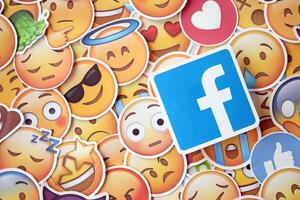 KYIV, UKRAINE - APRIL 20, 2024 Facebook logo and large set of stickers with Emoji yellow faces. Emoji is a pictogram or smiley embedded in text and used in electronic messages photo