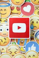 KYIV, UKRAINE - APRIL 20, 2024 YouTube logo and large set of stickers with Emoji yellow faces. Emoji is a pictogram or smiley embedded in text and used in electronic messages photo